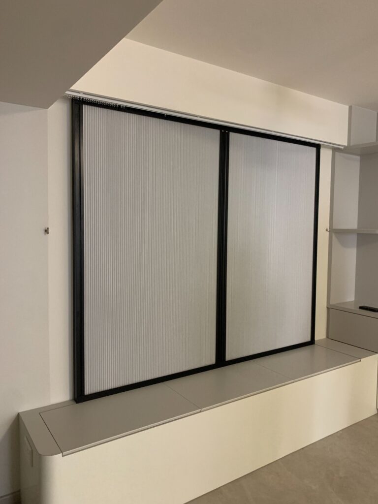 White day-night panel-glide blinds mounted on a black track in a bedroom