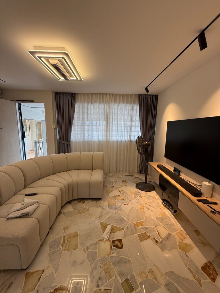 Sheer and dim-out day-night curtains in a renovated living room with a curved sofa and marble flooring